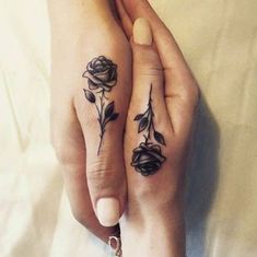 two people with matching tattoos on their hands, one holding the other's hand