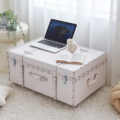 an open suitcase sitting on top of a white rug next to a laptop and teddy bear