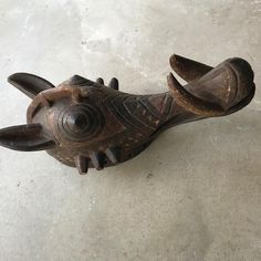 an old wooden animal head on the floor