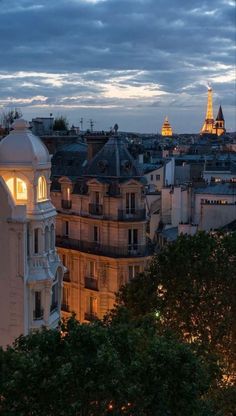 the eiffel tower is lit up in the evening sky over paris, france