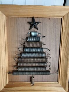 a christmas tree made out of springs in a wooden frame with a star on top