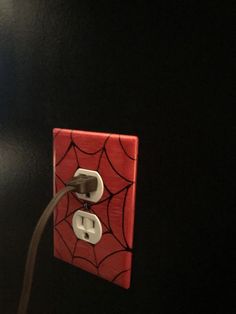 an electrical outlet with a spider - web design on the cover is plugged in