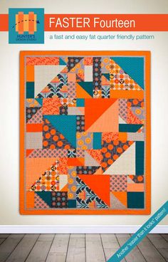 an orange and blue quilt hanging on a wall