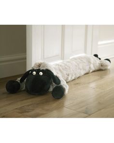 a stuffed animal laying on top of a wooden floor next to a white door way