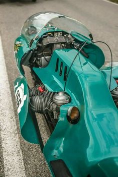 a close up of a motorcycle parked on the side of the road next to a car