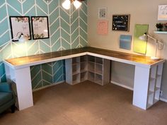 a corner desk with shelves underneath it and a chair next to it in front of the wall