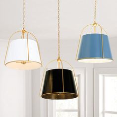 three lamps hanging from the ceiling in a room with white walls and blue curtains on the windowsill