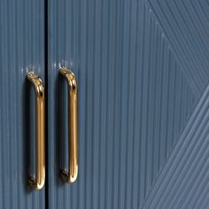 two gold handles on a blue door with vertical lines in the backgrounnd