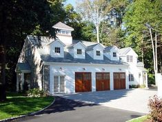 a large white house with two garages in the driveway