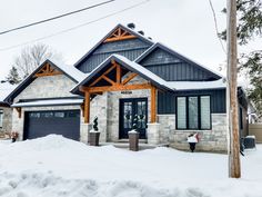 a house that is covered in snow and has two garages on the side of it