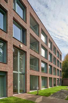 an apartment building with many windows and grass