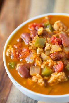 a white bowl filled with soup on top of a wooden table