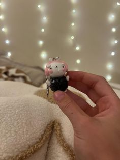 a hand holding a tiny hello kitty keychain