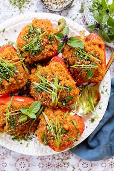 a white plate topped with stuffed peppers covered in herbs and seasoning on top of a table