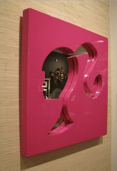 a pink sculpture is mounted on the wall