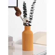 a vase with some plants in it on a table