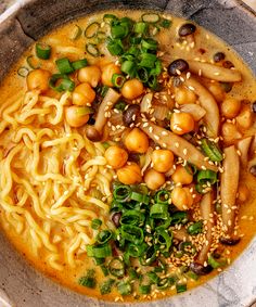 a bowl filled with noodles and vegetables on top of a table