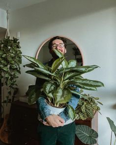 a person holding a potted plant in front of a mirror