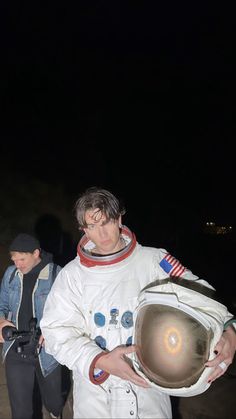 a man in an astronaut's suit is holding something