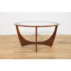 a glass and wood coffee table with curved legs