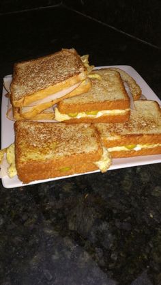 toasted sandwiches sitting on top of a white plate