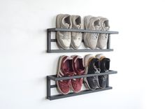 there are several pairs of shoes hanging on the wall next to each other in this shoe rack