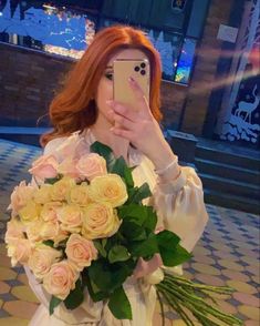 a woman taking a selfie while holding a bouquet of flowers in front of her face