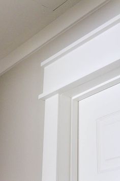 the corner of a white door with a small window in it's center area