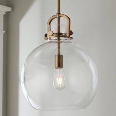 a glass globe light hanging from a ceiling fixture in a room with white walls and wood trimmings