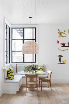 a dining room with white walls and wood flooring is decorated with birds on the wall