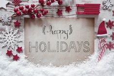 a sign that says happy holidays surrounded by snowflakes and candy canes on a white wooden background