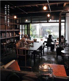 people are sitting at tables in the middle of a room with lots of bookshelves