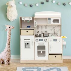 a child's play kitchen with a giraffe toy next to it