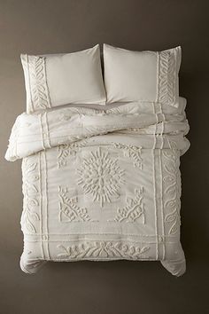 the bed is made with white linens and pillows