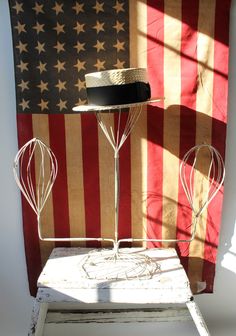 a hat is sitting on top of a stand in front of an american flag wall