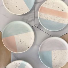 four plates sitting on top of a marble counter next to each other with different colors