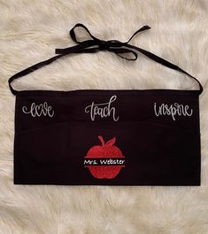 a black teacher's apron with an apple on it