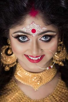 a woman with makeup and jewelry on her face