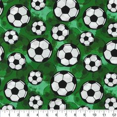 a green and black soccer ball pattern with white balls on the field in front of it