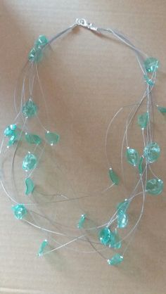 a necklace with green beads and leaves on it