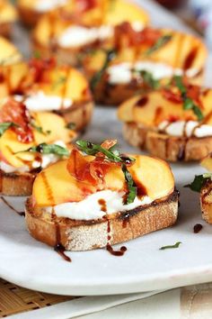 toasted bread topped with peaches and goat cheese on a plate next to other food items