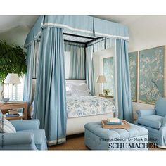 a bedroom with four poster bed and blue chairs