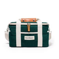 a green and white bag with leather handles