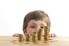 a young boy looking over stacks of coins