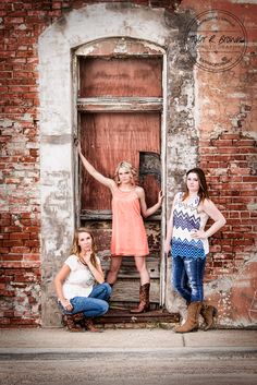 three girls posing in front of an old door