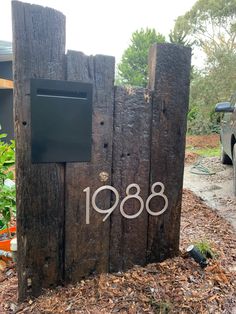 a wooden fence with the number 1088 on it and a mailbox attached to it