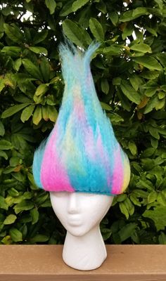 a white mannequin head with a multicolored hat on top of it