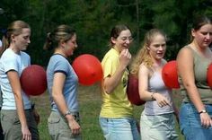 a group of young women standing next to each other with red balloons in front of them