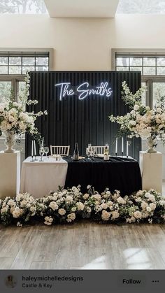 the table is set up with white flowers and greenery for an elegant wedding reception