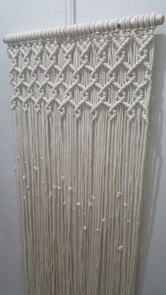 the wall hanging is made out of white yarn